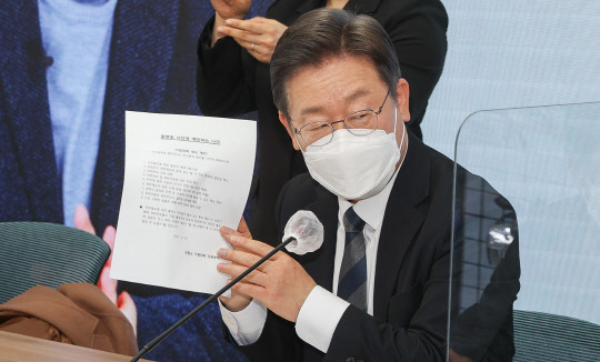 이재명 민주당 대선후보가 20일 서울 여의도 중앙당사에서 열린  전국민 선대위 회의에서 '가정위탁 제도 제안'을 들어보이고 있다. 국회사진기자단=연합뉴스